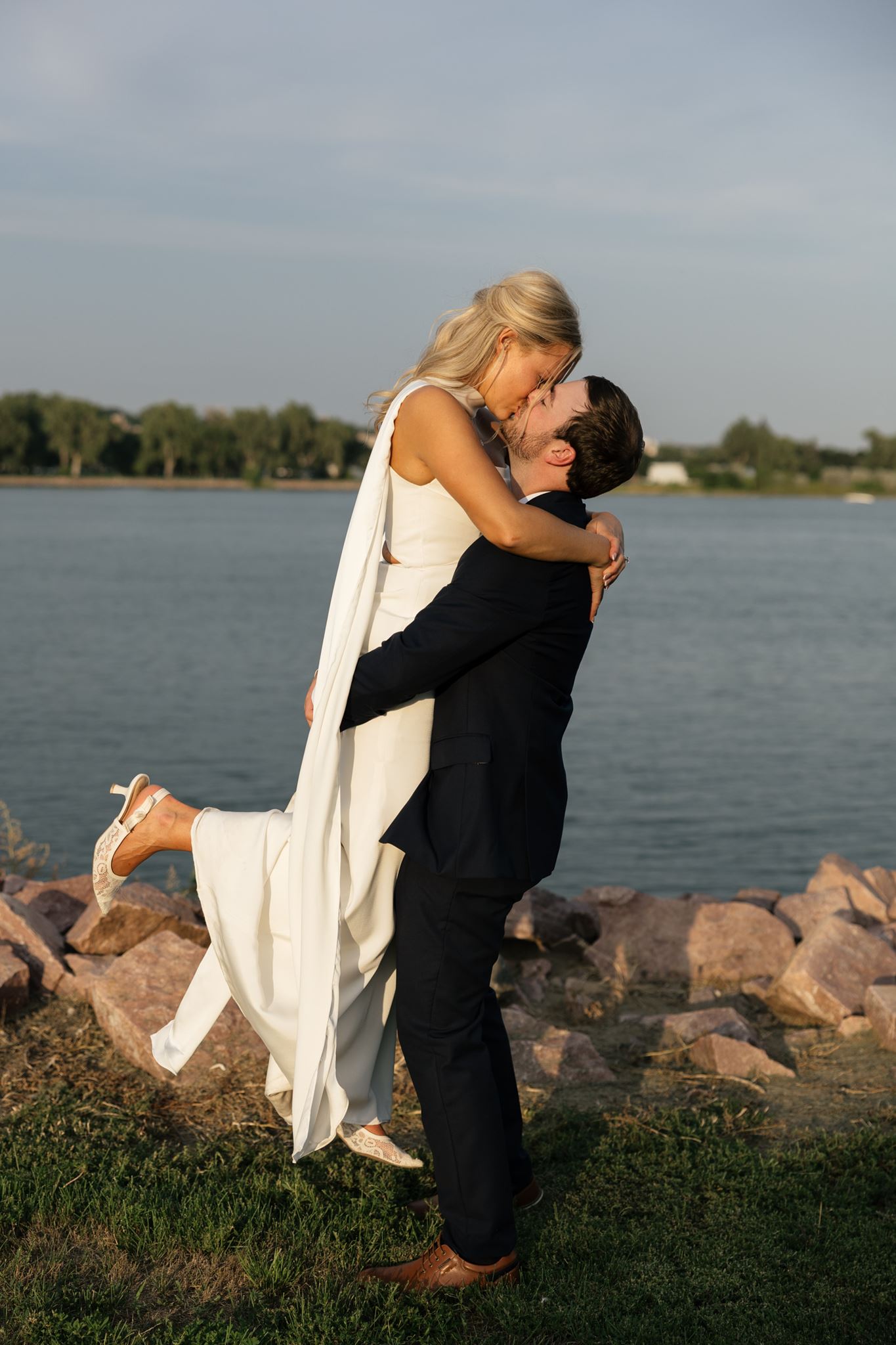 Bride and groom embracing by the Missouri River at Drifters Event Center in Pierre, South Dakota